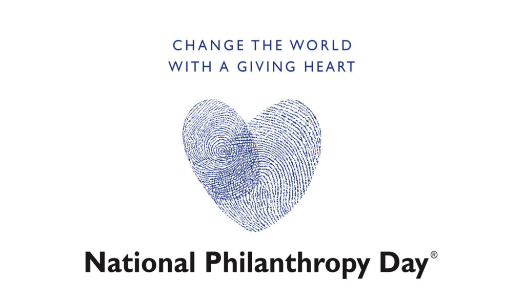 white background with a blue writing on top saying "change the word with a giving heart" and a blue heart below, with the writing "National Philanthropy Day" in blue