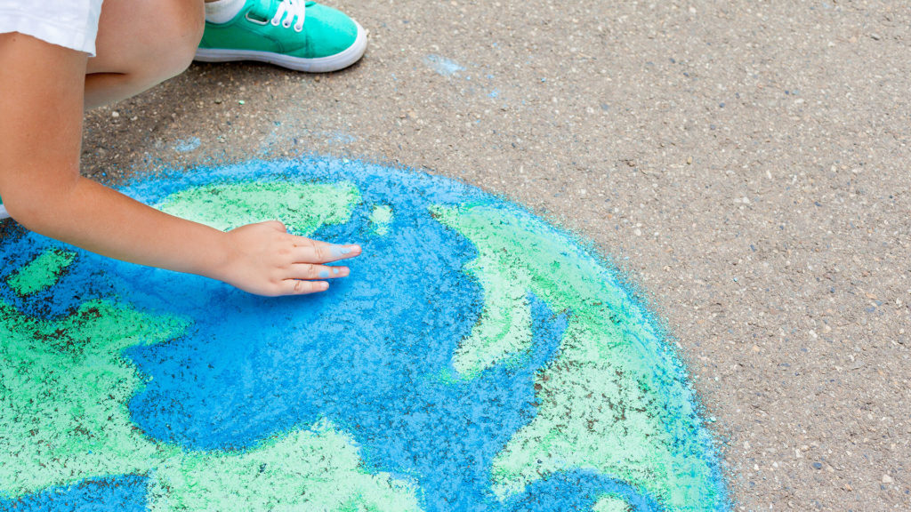 how impact investing drives change- globe draw with chock on the floor painted by a children's hand