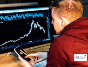 man wearing red hood staring a computer screen with financial chart
