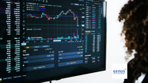 woman standing in front of screen with stock market charts in it