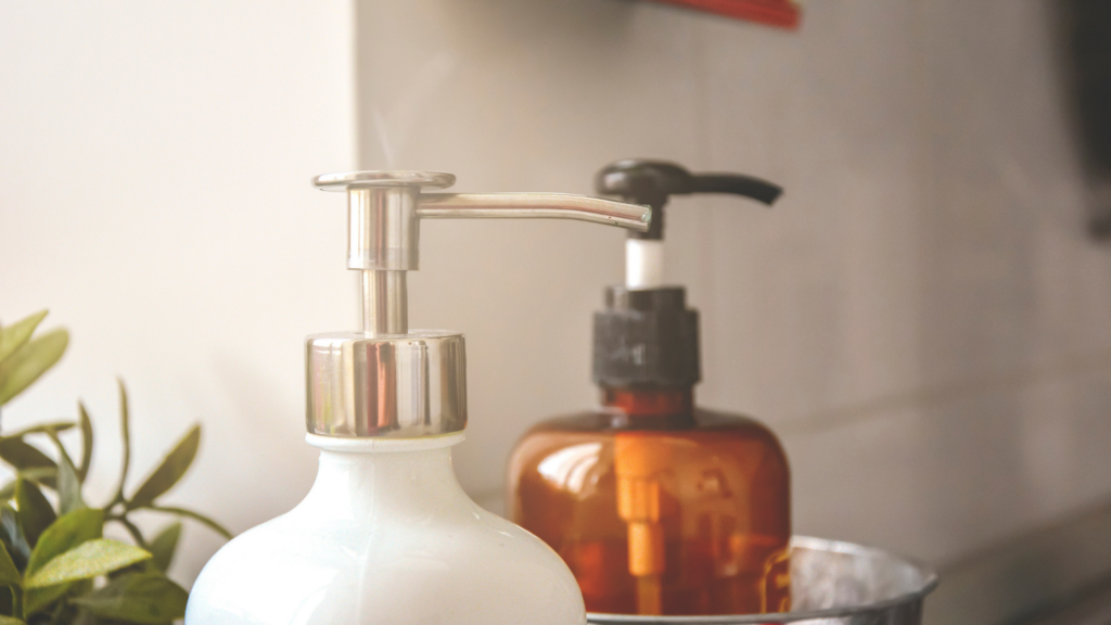 a white soap pump and a tinted glass soap pump